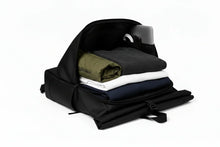 Charger l'image dans la galerie, Sac à dos noir Trekker Ss ouvert avec vêtements pliés et ordinateur portable à l'intérieur